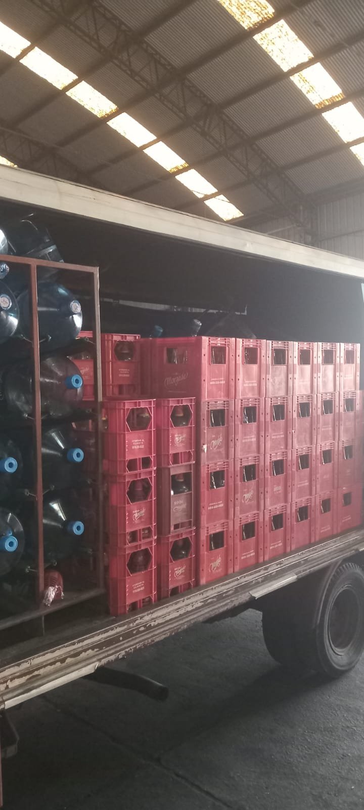 Camión cargado con bidones de agua y cajones de sifones de soda para el reparto