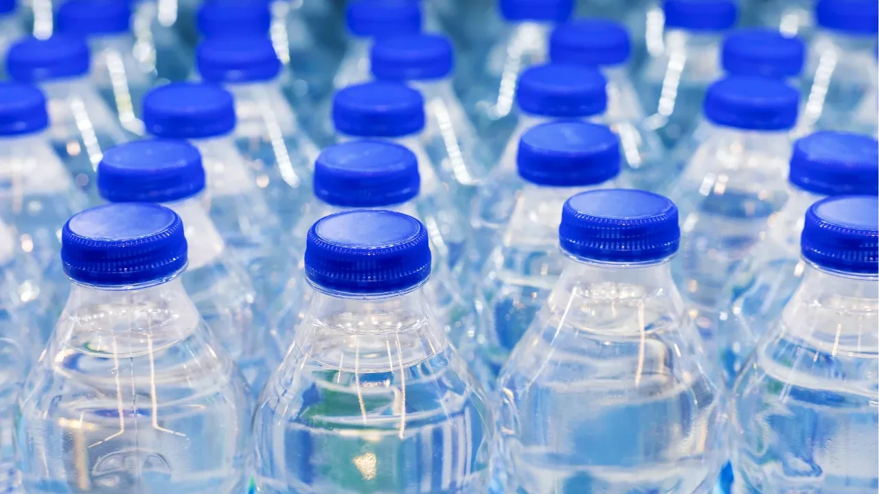 Fila de botellas de agua embotellada con tapa azul